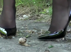 Lena crushing snails far her off colour black heels.